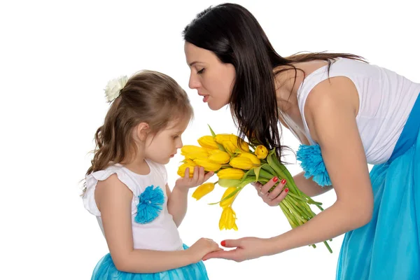 Mutter und Tochter riechen gelbe Tulpen. — Stockfoto