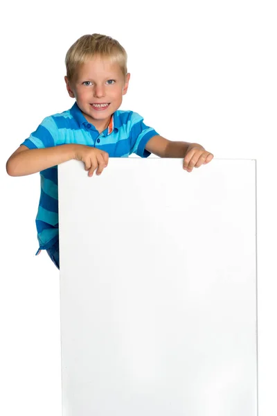 A little boy is looking from behind an empty banner. — Stock Photo, Image