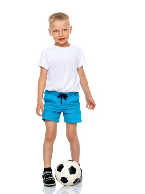 Küçük çocuk bir futbol topuyla oynuyor.