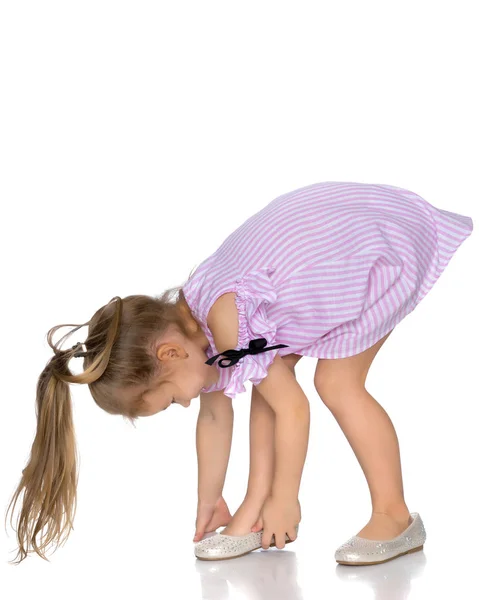 The little girl puts on her shoes. — Stock Photo, Image