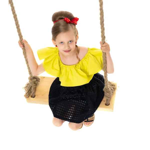 Joyeuse petite fille balançant sur une balançoire. — Photo