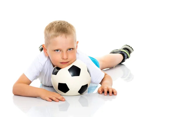 Menino está jogando com uma bola de futebol . — Fotografia de Stock