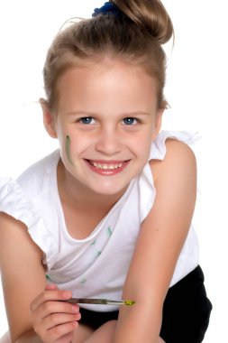 Küçük bir kız boya ve fırça ile boya.