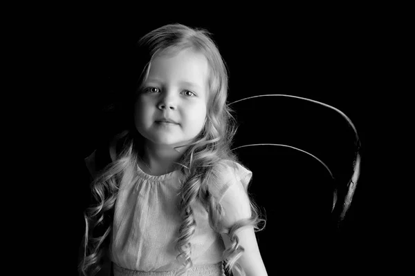 Klein meisje op een zwarte achtergrond — Stockfoto