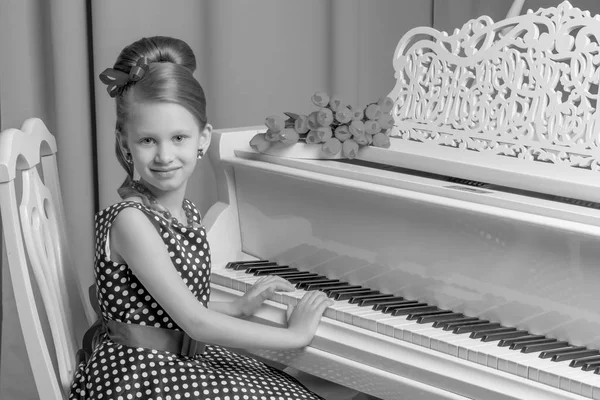 Küçük kız piyano, siyah ve beyaz fotoğraf çalış.