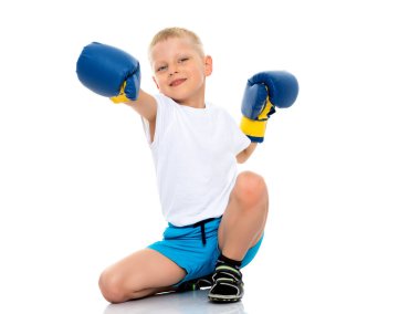 Küçük bir çocuk temiz beyaz bir T-shirt ve boks eldiveni.