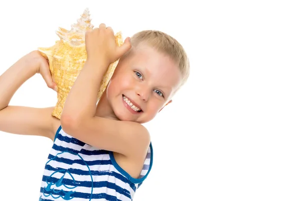 Ein kleiner Junge mit einer Muschel. — Stockfoto