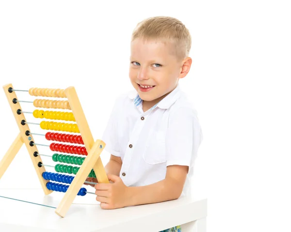 Mały chłopiec używa abacus do rozwiązywania problemów matematycznych. — Zdjęcie stockowe