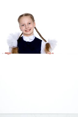 Küçük bir kız boş bir pankartın arkasından bakıyor..