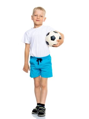 Küçük çocuk bir futbol topuyla oynuyor.