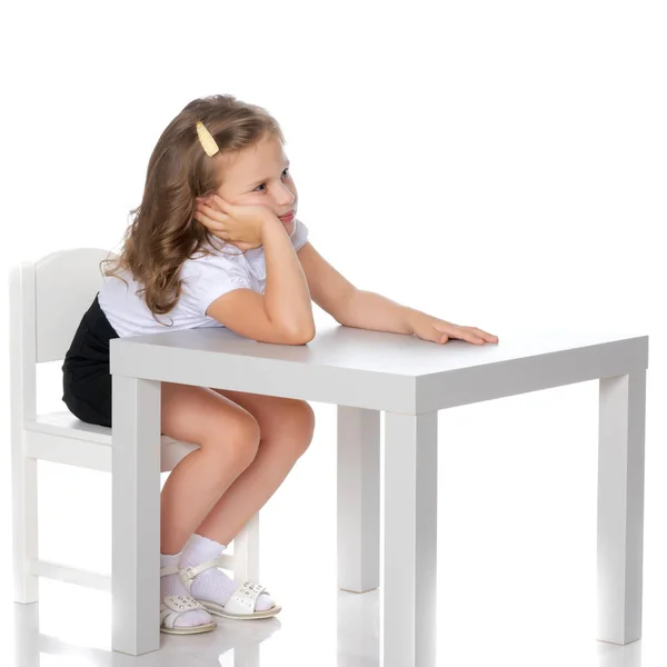 Liten flicka sitter vid bordet — Stockfoto