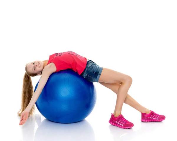 Niña haciendo ejercicios en una pelota grande para la aptitud. — Foto de Stock