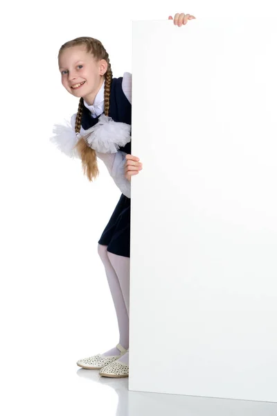 Una bambina sta guardando da dietro uno striscione vuoto. — Foto Stock