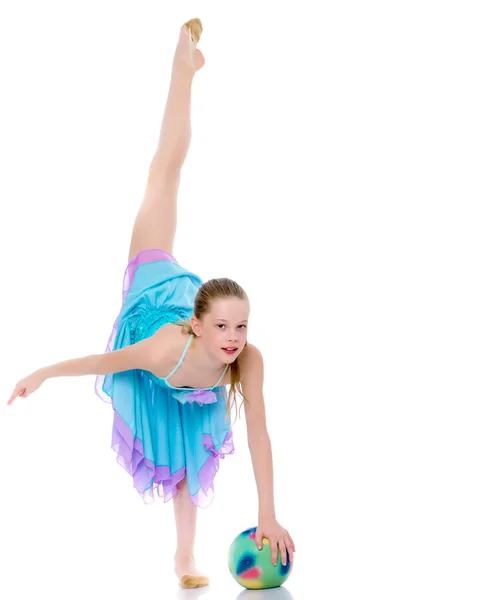 Flicka gymnast utför övningar med bollen. — Stockfoto