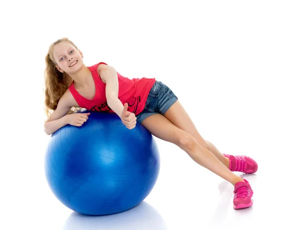 Niña haciendo ejercicios en una pelota grande para la aptitud. — Foto de Stock