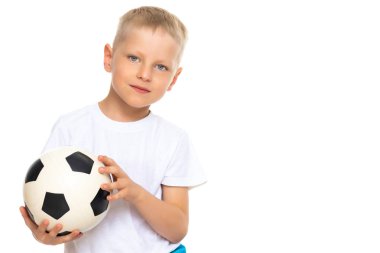 Küçük çocuk bir futbol topuyla oynuyor.