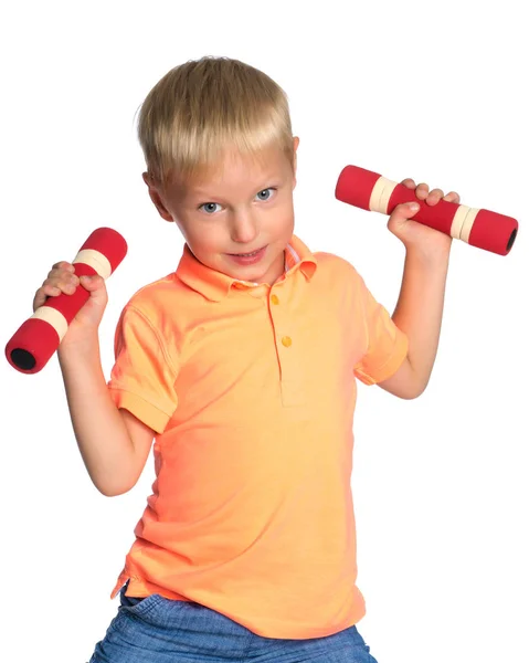 Een kleine jongen is het opheffen van halters. — Stockfoto