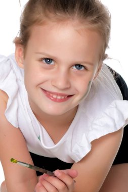 Küçük bir kız boya ve fırça ile boya.