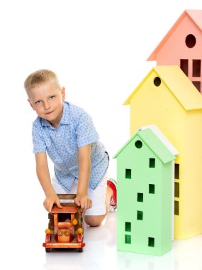 Küçük çocuk bir ahşap araba ile oynuyor.