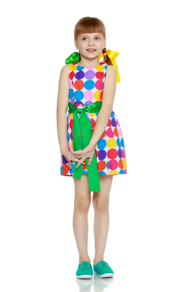 Маленькая девочка в платье с рисунком из разноцветного цирка — стоковое фото