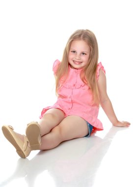 Küçük kız yerde oturuyor..