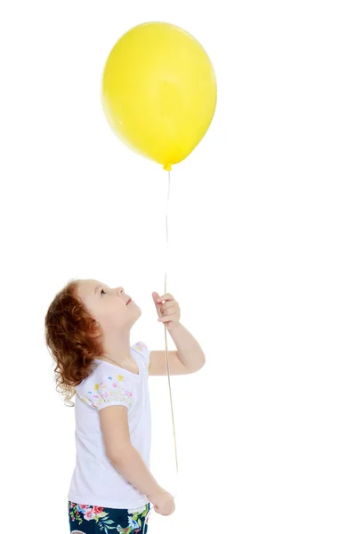 Маленькая девочка играет с воздушным шаром — стоковое фото