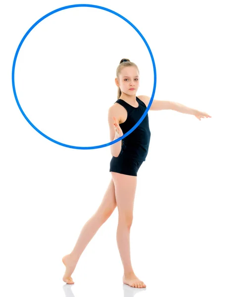 A girl gymnast performs an exercise with a hoop. — Stock Photo, Image