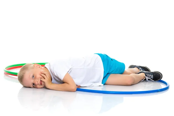 Happy little boy is lying on the floor in the studio. — Stock Photo, Image