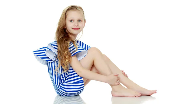 Adorable little blond girl in very short summer striped dress. — Stock Photo, Image