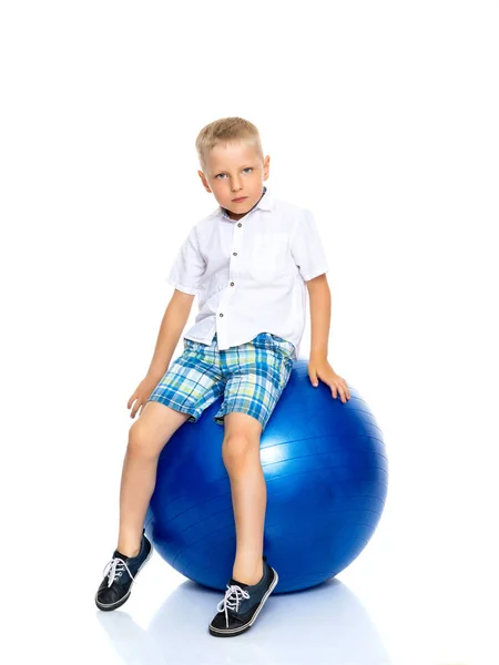 Um menino está brincando com uma bola . — Fotografia de Stock