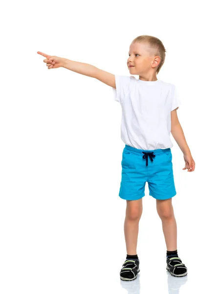 Маленький мальчик в чистой белой футболке указывает на что-то . — стоковое фото