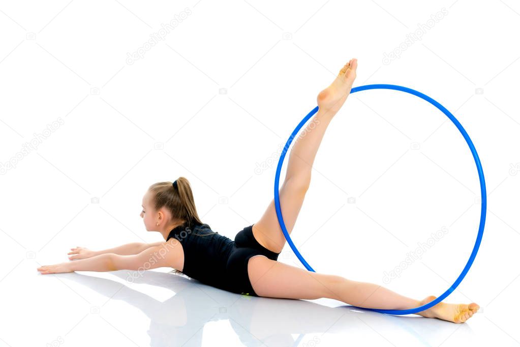 A girl gymnast performs an exercise with a hoop.