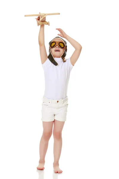 Little girl with a wooden plane in her hand. — Stock Photo, Image