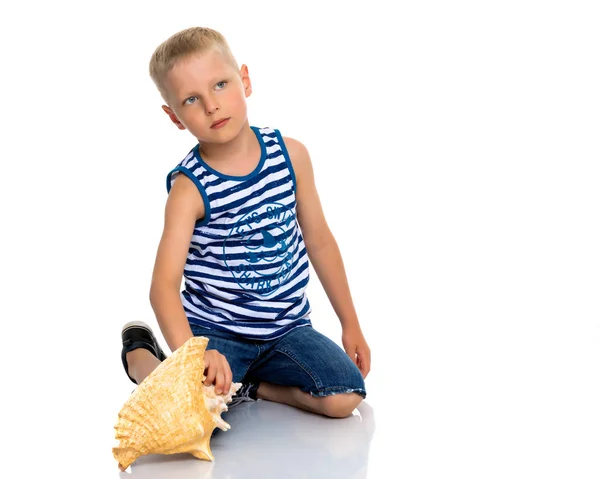 Un niño pequeño con una concha de mar . —  Fotos de Stock