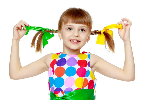 Ένα μικρό κορίτσι σε ένα φόρεμα με μοτίβο από πολύχρωμα κύκ Royalty Free Φωτογραφίες Αρχείου