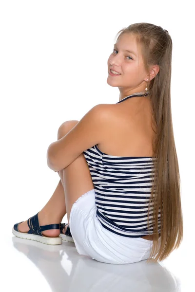 Een tienermeisje is zittend op de vloer. — Stockfoto