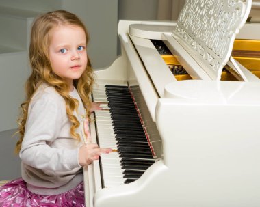 Kız beyaz piyanonun başında..
