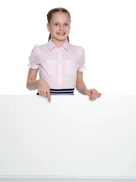 Little girl is showing a finger on a white banner. — Stock Photo, Image