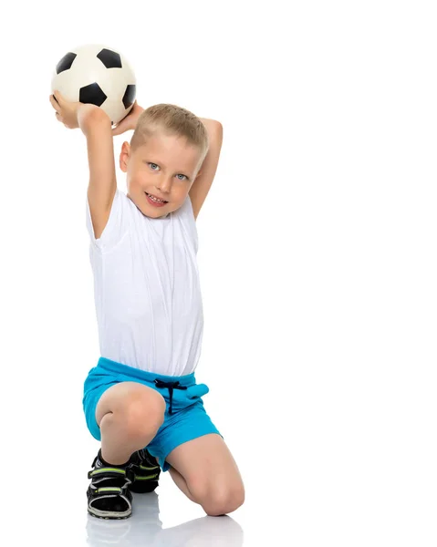 Malý chlapec hraje s fotbalovým míčem. — Stock fotografie