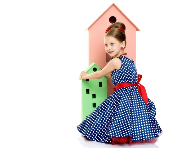 Little girl is playing with wooden houses. — Stock Photo, Image