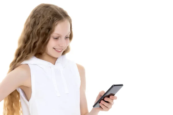 Het meisje is met behulp van een mobiele telefoon. — Stockfoto