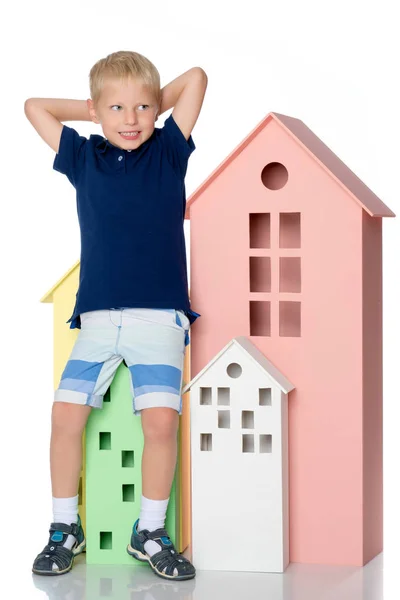 Um menino está brincando com casas coloridas . — Fotografia de Stock