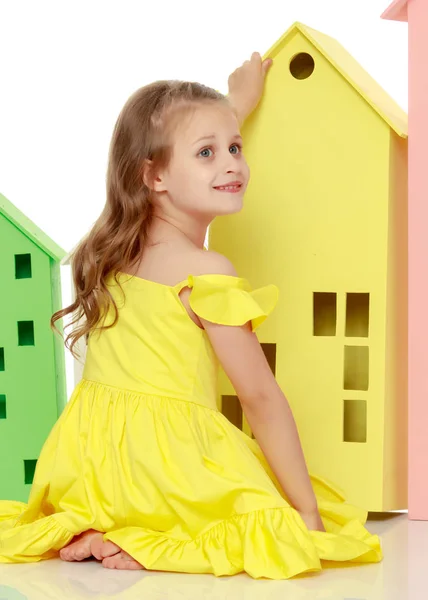 Little girl is playing with wooden houses. — Stock Photo, Image