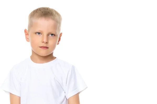 En liten pojke i en vit T-shirt. — Stockfoto
