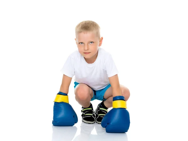 Een jongetje in een schone witte T-shirt en bokshandschoenen. — Stockfoto