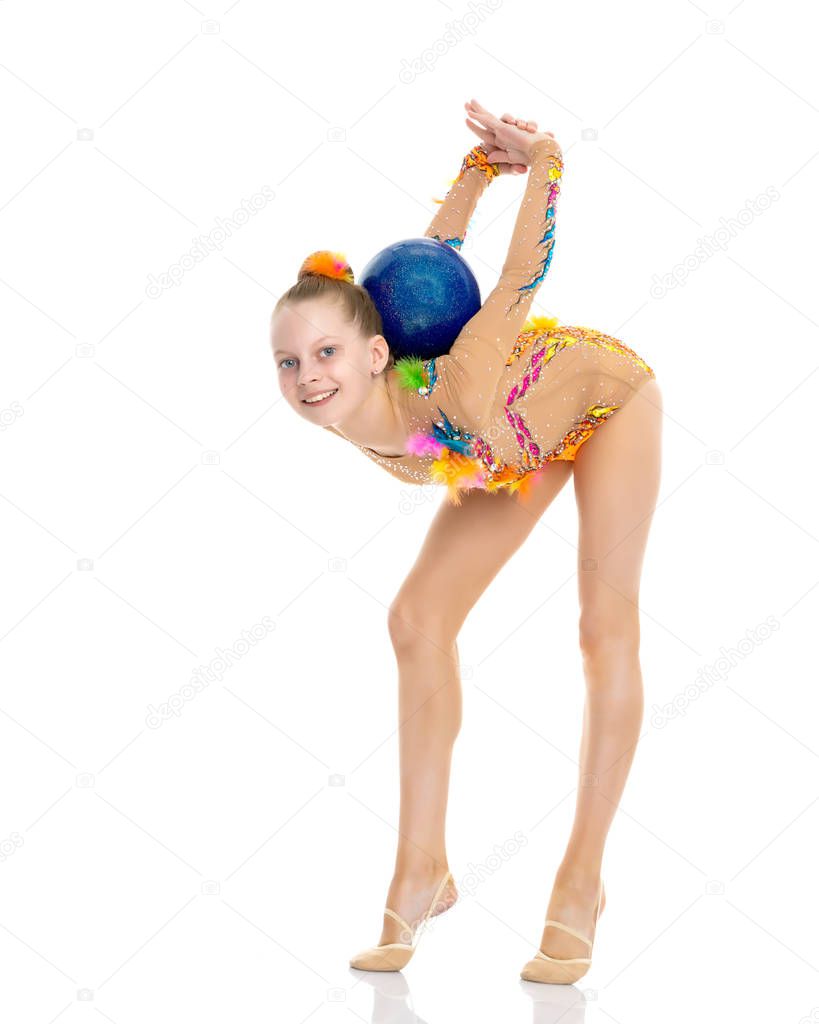 Girl gymnast performs exercises with the ball.