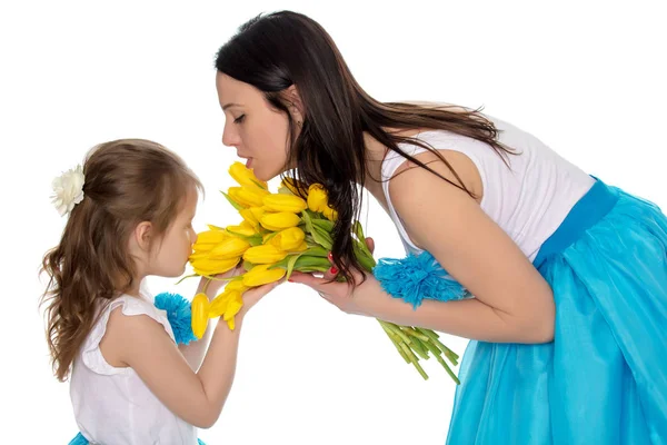 Madre e figlia che odorano di tulipani gialli . — Foto Stock