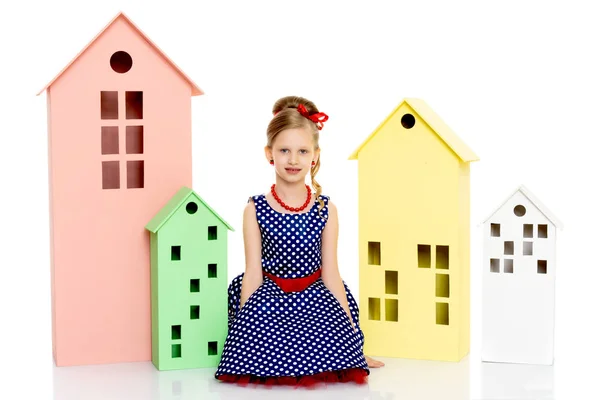 Little girl is playing with wooden houses. — Stock Photo, Image