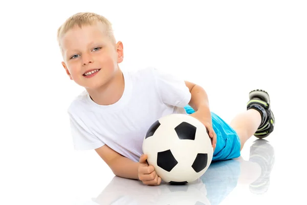 Μικρό αγόρι παίζει με μια μπάλα ποδοσφαίρου. — Φωτογραφία Αρχείου