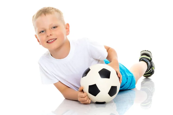 Menino está jogando com uma bola de futebol . — Fotografia de Stock